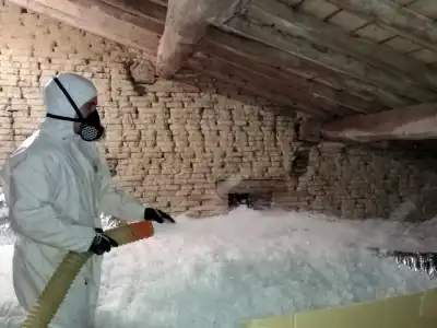 un artisan posant une isolation de comble perdu en laine de verre nouvelle génération un artisan posant une isolation de comble perdu en laine de verre nouvelle génération