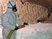 Photo d'un professionnel en train d'isoler un comble perdu à Toulouse avec de la laine de roche soufflée.